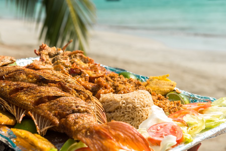 Bandeja con pescado frito, arroz de coco, salpicón, ensalada y patacones.